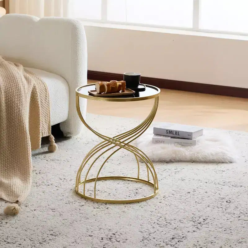 Table d’appoint élégante et moderne en forme de sablier, avec plateau en verre noir et piètement en métal doré